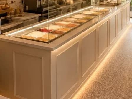 Trays of gelato in the lit display case at DiLatte
